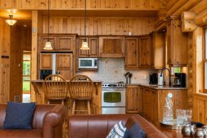a kitchen with wooden cabinets and a couch at Fiddler Lake Resort - Deer 79 in Mille-Isles