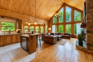 a kitchen and living room in a log cabin at Fiddler Lake Resort - Deer 79 in Mille-Isles