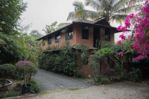 a brick house with pink flowers in front of it at Valhalla Villa in Panvel