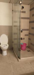 a bathroom with a toilet and a glass shower stall at GM Hospitality Services pune in Pune