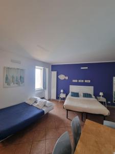 a bedroom with two beds and a blue wall at Vibes 5terre in Riomaggiore