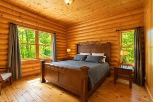 a bedroom with a bed in a log cabin at Fiddler Lake Resort - Deer 79 in Mille-Isles +19 photos