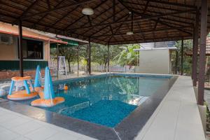 an empty swimming pool with an umbrella and an inflatable at Valhalla Villa in Panvel