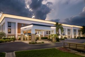 a large white building with a parking lot at Hampton Inn Naples - I-75 in Naples