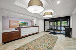 a waiting room with a reception desk and a rug at Hampton Inn Naples - I-75 in Naples +33 photos