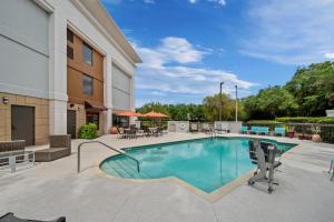 a pool at a hotel with chairs and tables at Hampton Inn Naples - I-75 in Naples