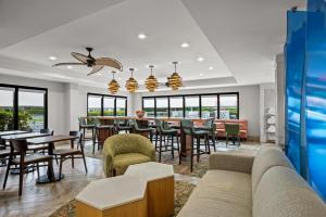 a living room with a couch and tables and chairs at Hampton Inn Naples - I-75 in Naples