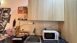 a kitchen with a microwave and a sink at Golden Nest Stays in Ghaziabad
