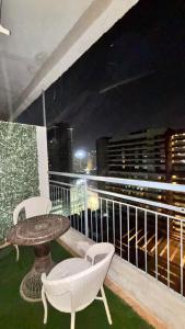 a table and chairs on a balcony at night at Golden Nest Stays in Ghaziabad +2 photos