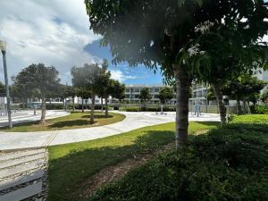 a park with a tree and a building in the background at VH HOMES l Imago Mall l 2BR Family Suite l Garden Direct Access in Kota Kinabalu
