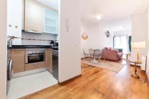 an open kitchen and living room with a couch at Apartamentos El Escudo Centro in Ribadesella +10 photos