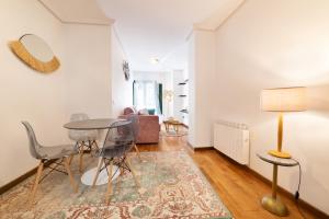 a living room with a table and chairs at Apartamentos El Escudo Centro in Ribadesella