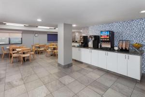 a restaurant with a cafeteria with tables and chairs at AmericInn by Wyndham Appleton North Little Chute in Appleton