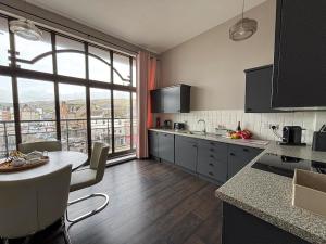 a kitchen with a table and a large window at Seaside Penthouse 1 in Largs