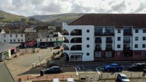 a building in a city with cars parked in a parking lot at Seaside Penthouse 1 in Largs