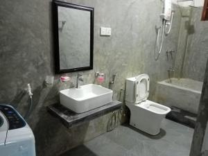 a bathroom with a sink and a toilet and a mirror at Mariya Villa in Unawatuna