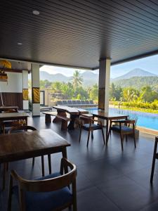 a restaurant with tables and chairs and a pool at Bukit Luwih House in Munduk