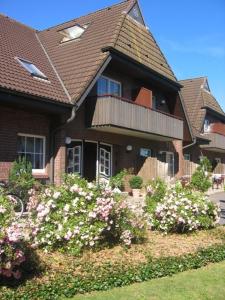 ein großes Haus mit Blumen davor in der Unterkunft Friesenhof in Friedrichskoog