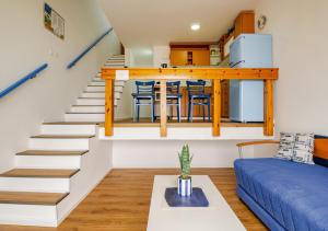a living room with stairs and a blue couch at Nahariya SEA VIEW, Ha-aliya in Nahariyya