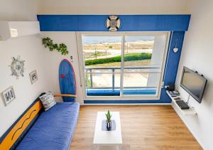a living room with a blue couch and a tv at Nahariya SEA VIEW, Ha-aliya in Nahariyya