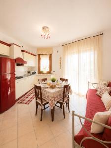 a kitchen and living room with a table and a couch at Residence Roberta con piscina - Agenzia Cocal in Caorle