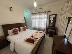 a bedroom with a bed with white sheets and a mirror at Titanic Villa Kandy in Kandy