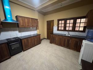 a large kitchen with wooden cabinets and a stove at Titanic Villa Kandy in Kandy