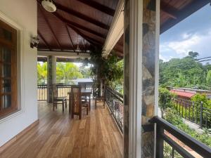an open porch with a table and chairs on a balcony at Titanic Villa Kandy in Kandy