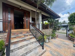 a house with a wooden staircase leading to a porch at Titanic Villa Kandy in Kandy +9 photos