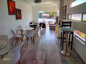 a restaurant with tables and chairs in a room at Dante Guest house in Alberton
