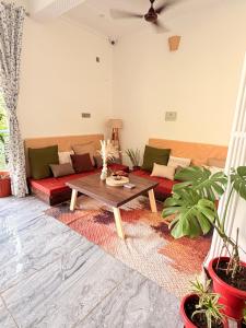 a living room with a couch and a table at Aahista Stays- Mountain view homestay in Bīr