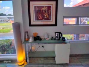 a desk in a room next to a window at Dante Guest house in Alberton