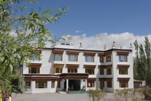 a large white building with wooden accents at Ratna Hotel Ladakh in Leh