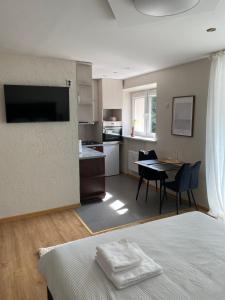 a bedroom with a bed and a kitchen with a table at S&A2 apartamentai in Panevėžys