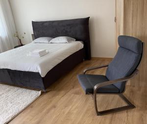 a bedroom with a bed and a chair at S&A2 apartamentai in Panevėžys