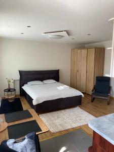 a bedroom with a large bed and a blue chair at S&A2 apartamentai in Panevėžys