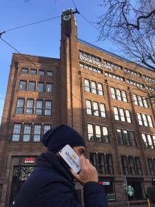 un hombre hablando por un celular en frente de un edificio en Hotel Ristorante Sbranetta, en Rozzano