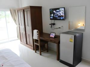 a kitchen with a desk and a refrigerator in a room at Iyara Residence in Trat
