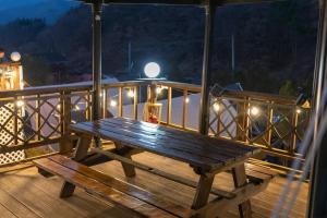 a wooden bench sitting on a deck at night at Jade Byeolbit Caravan in Chuncheon