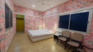 a bedroom with a bed and a brick wall at Tulsipur Agro Park in Mirzāpur