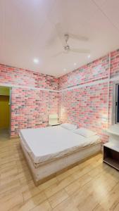 a bedroom with a large bed in a brick wall at Tulsipur Agro Park in Mirzāpur