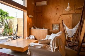 a hammock in a room with a table and a kitchen at anandahの宿 in Miyazaki