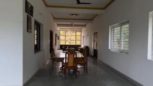 a dining room with a table and chairs at Yashaswi Hilldeck in Sondekoppa