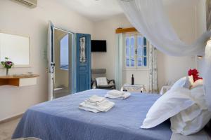 a bedroom with a blue bed with towels on it at Yiorgo's Studios in Kalymnos