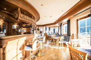 um restaurante com um bar e mesas e cadeiras em Turmhotel Gschwendt em Valle Di Casies