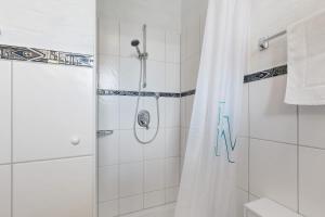 a bathroom with a shower with a shower curtain at Villa am Keltenberg - La Stella in Glauburg +14 photos