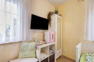 a small room with a tv and a shelf with a microwave at Villa am Keltenberg - La Stella in Glauburg