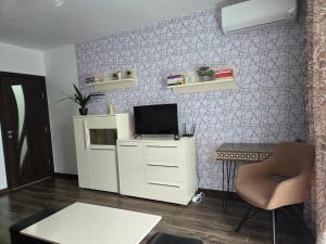 a living room with a tv on a wall at Azaria in Hisarya