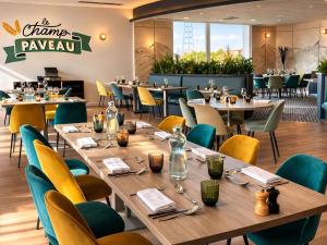 a dining room with tables and chairs and a restaurant at Novotel Reims Tinqueux in Reims