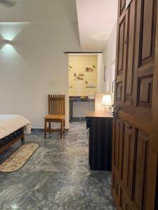 a room with a bed and a desk and a door at Daffodil in Anjuna +6 photos
